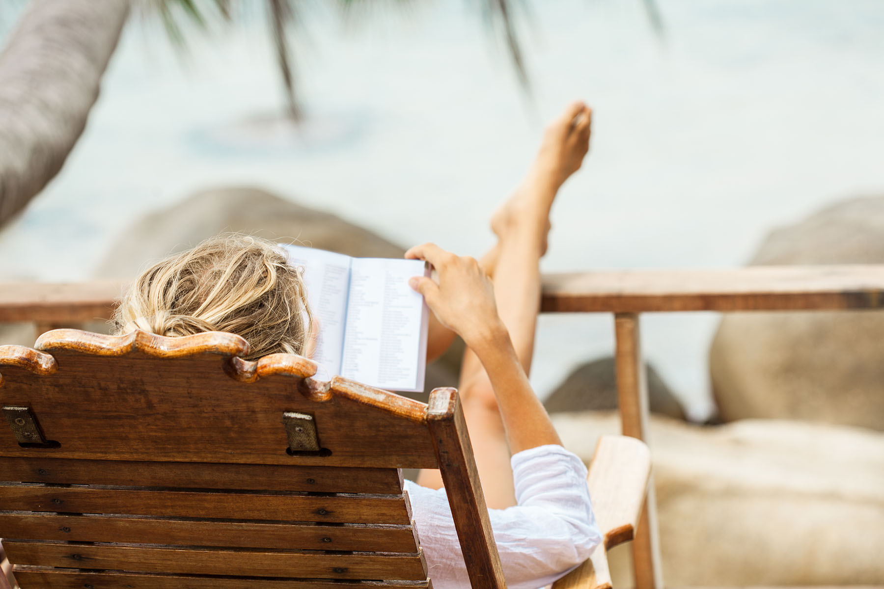 Woman relaxing reading beachside