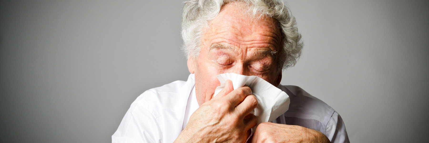 Man with runny nose using a tissue