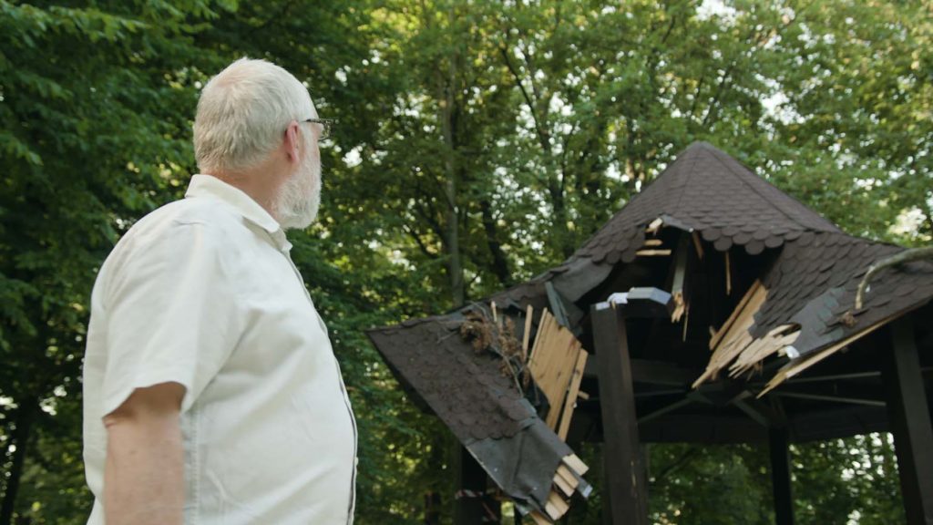 Older man looks at storm damage