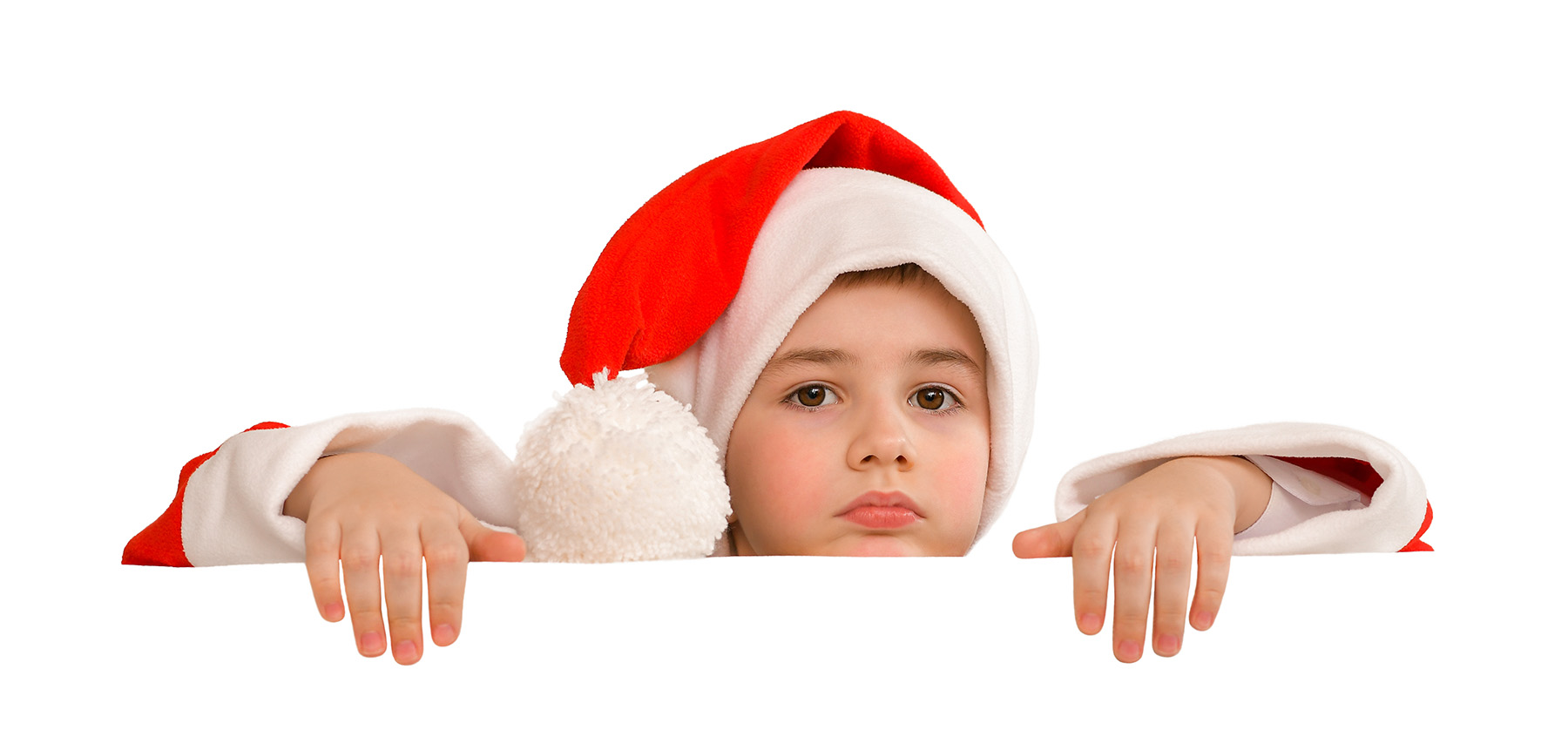 Kid in Santa outfit peers over white table or railing