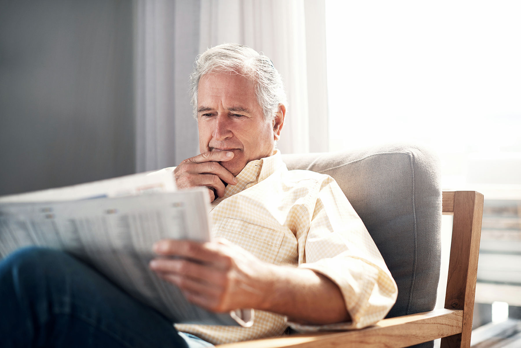 elderly man reading a newspaper