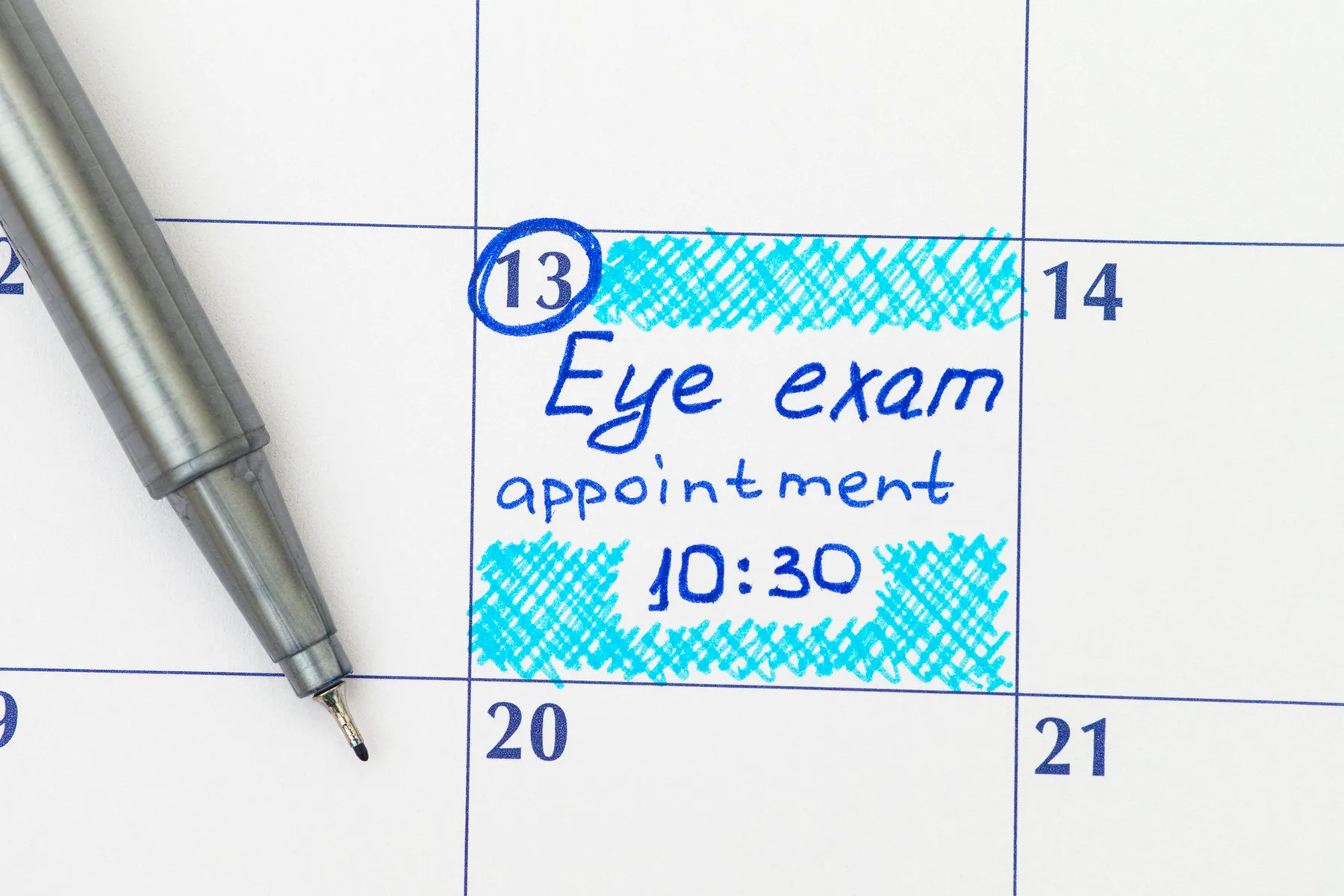 Calendar showing an eye exam appointment on the 13th at 10:30, written in blue ink and highlighted. A gray pen rests beside the marked date.