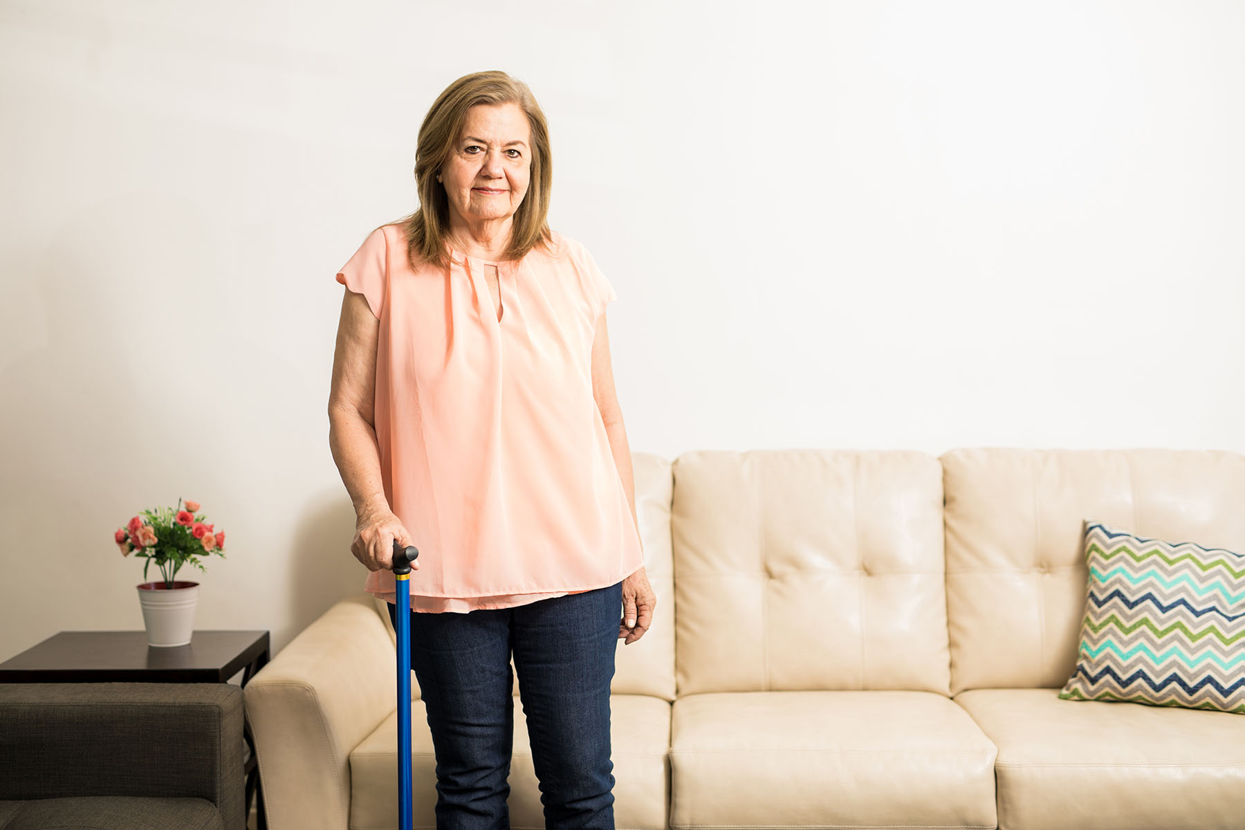 Woman with can stands in front of couch