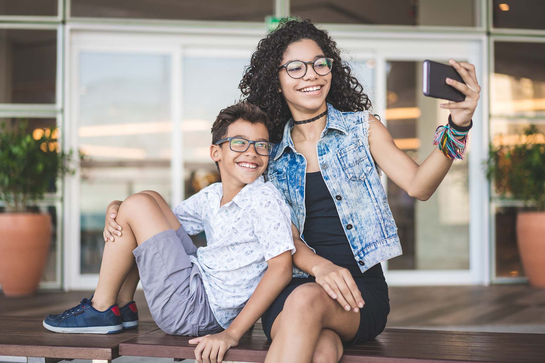Girl and boy in glasses happily taking selfie