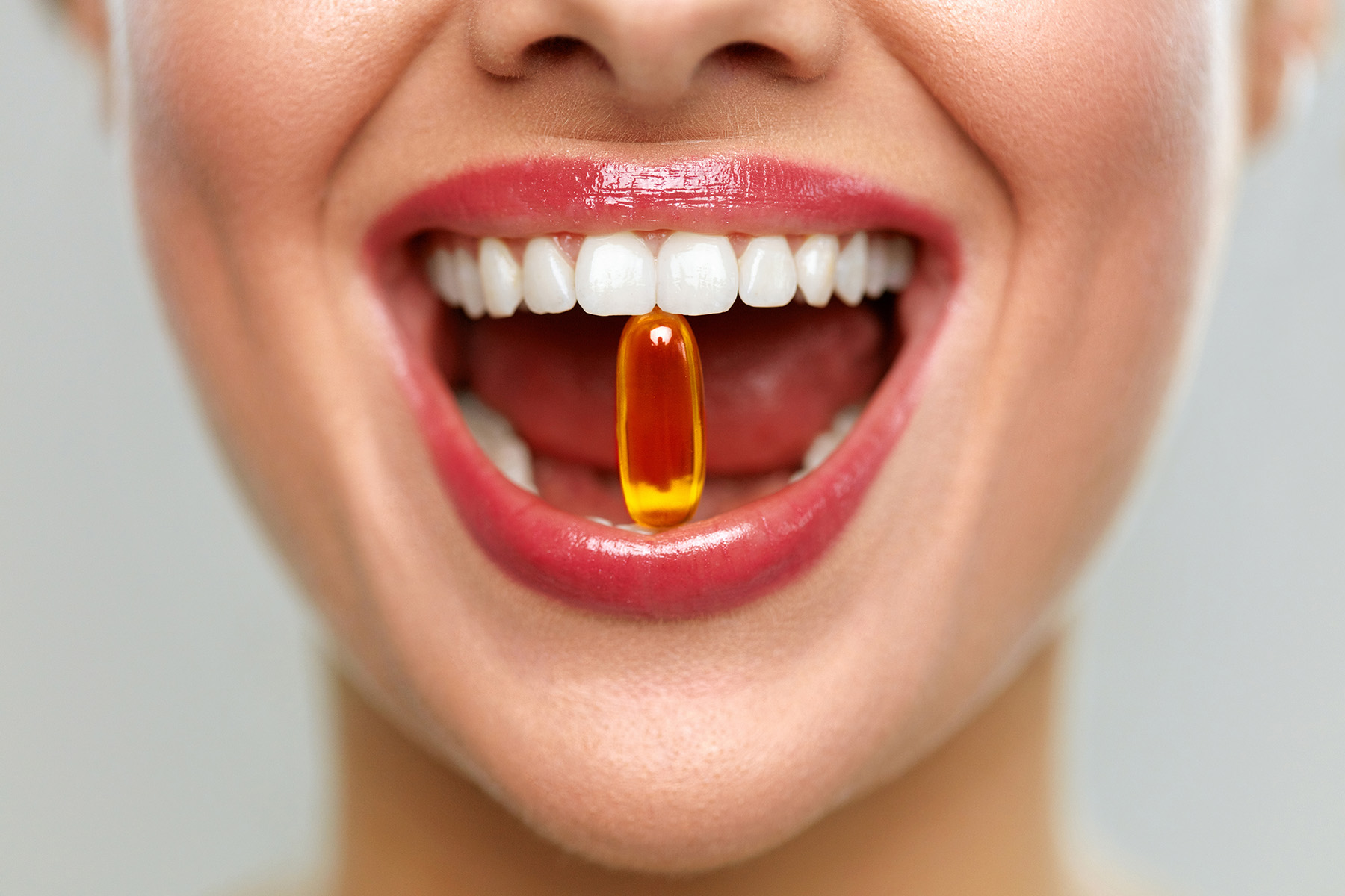 Woman Mouth With Pill In Teeth. Girl Taking Vitamins