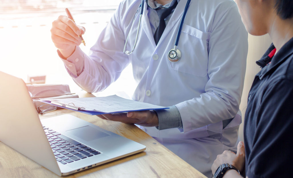 man speaking with doctor at consult
