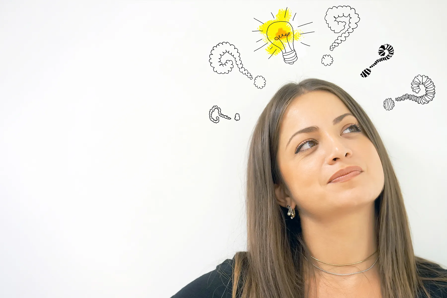 Young woman looking thoughtfully at a bright idea lightbulb and swirling question marks, representing problem-solving and inspiration.