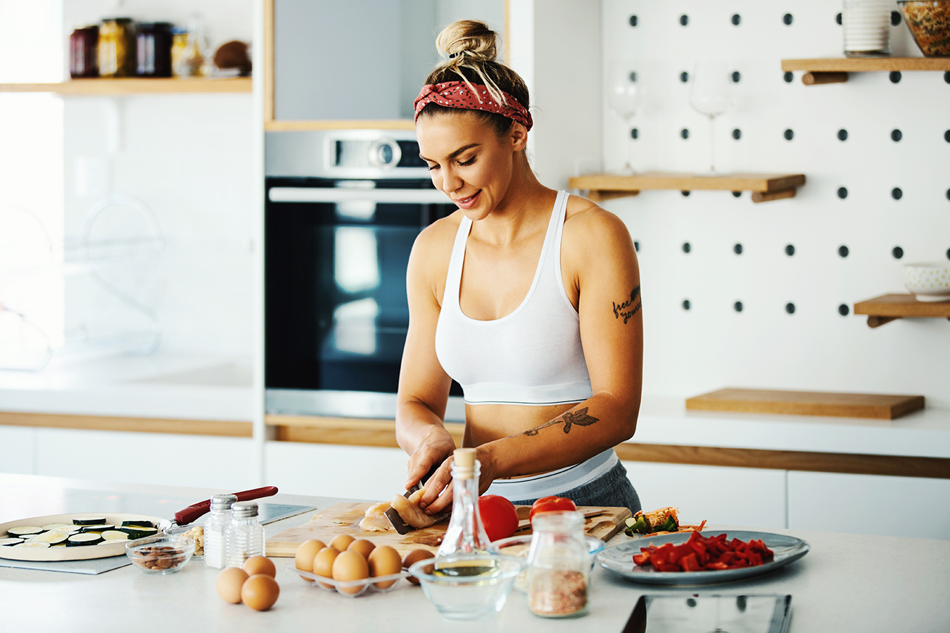 Young athletic woman preparing pre-workout meal in the kitchen.
