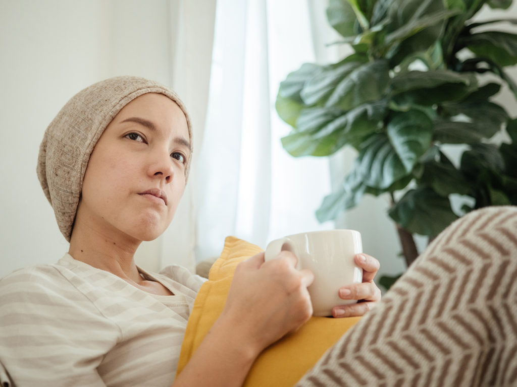 Female cancer patient rests on couch after radiation