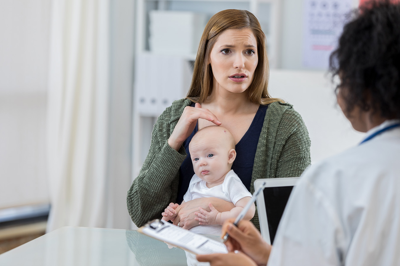 Woman with baby on lap asks doctor about AVMs