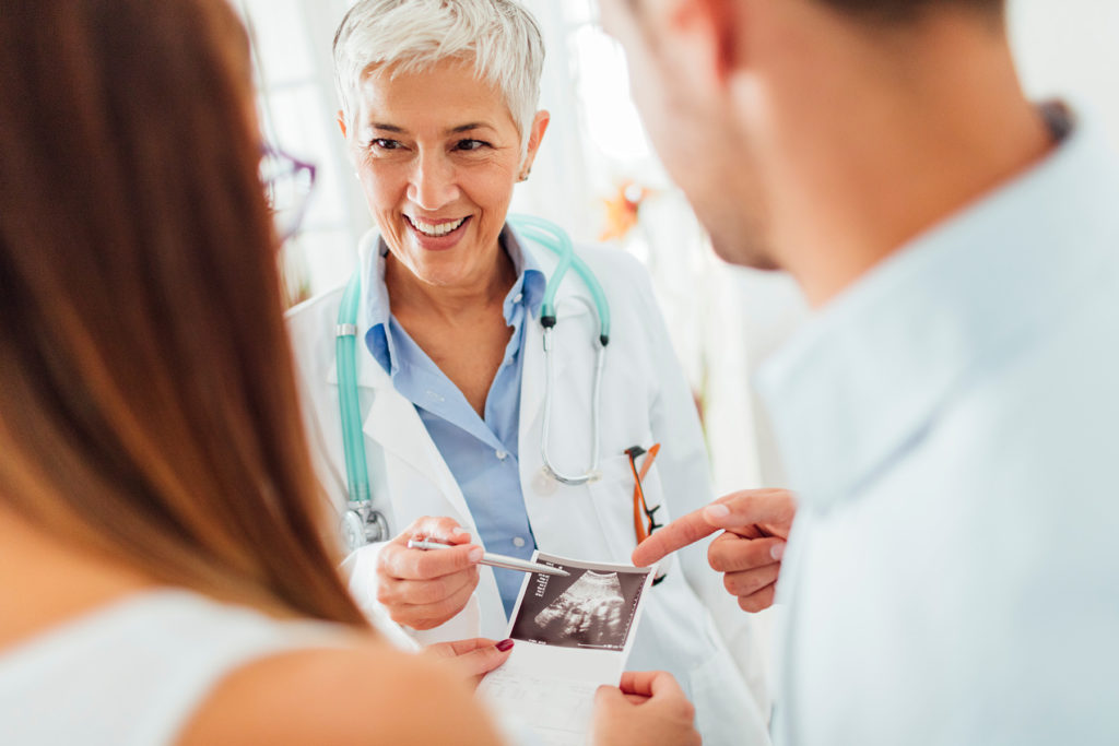 Young Couple with Doctor In A Consultation.