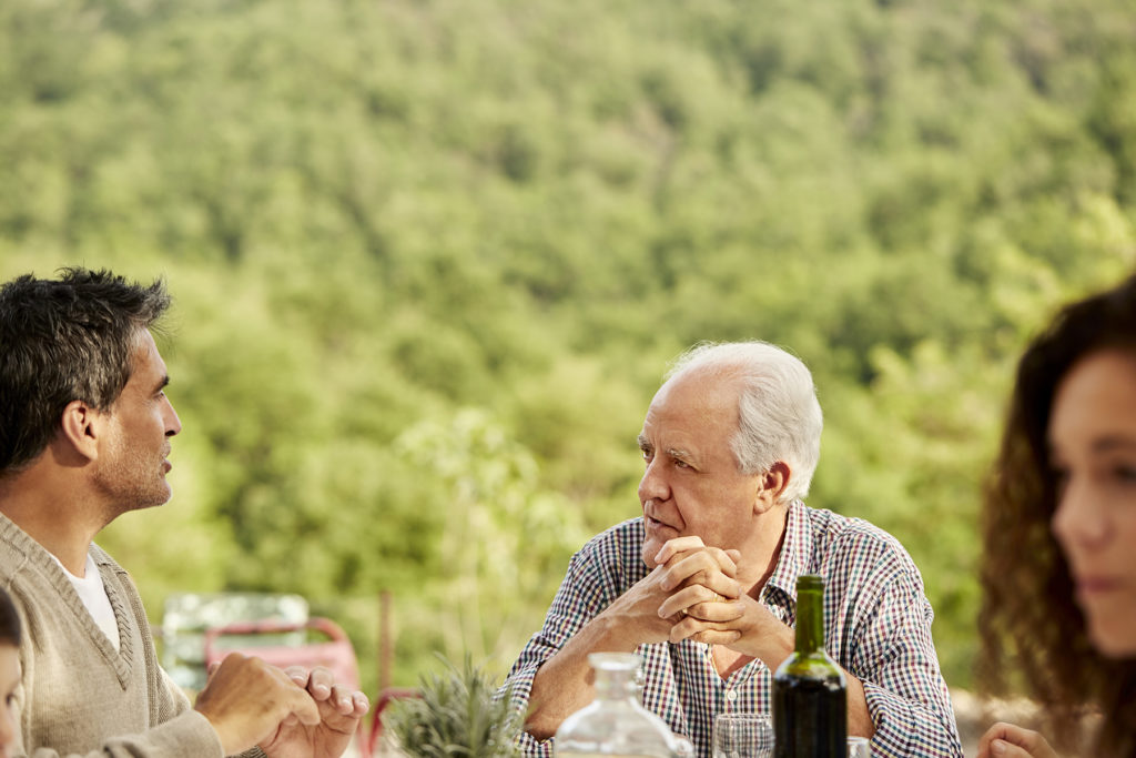 older father and son at family table