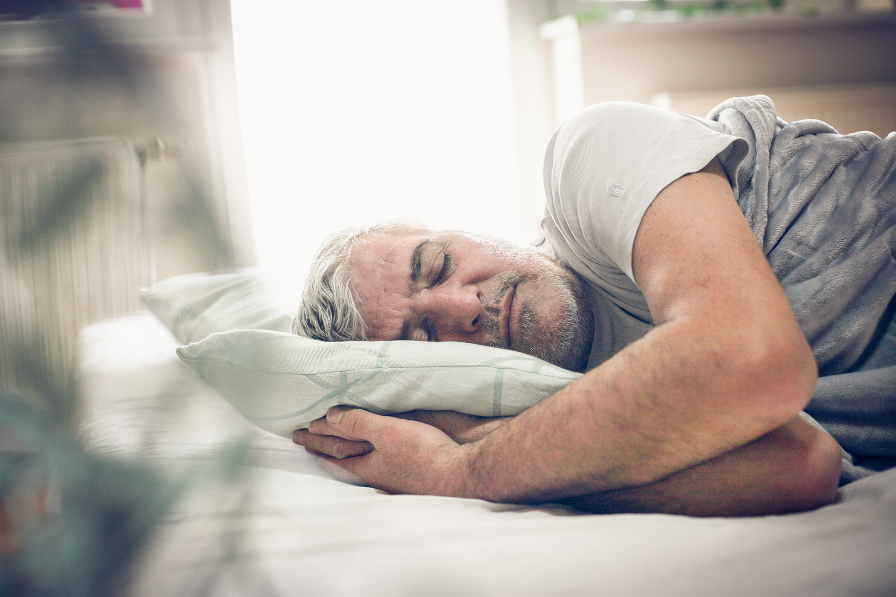 Older man in gray shirt sleeps