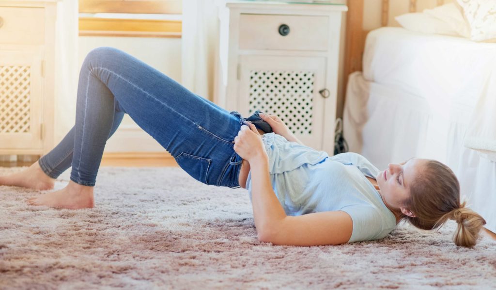 Woman squeezing into jeans