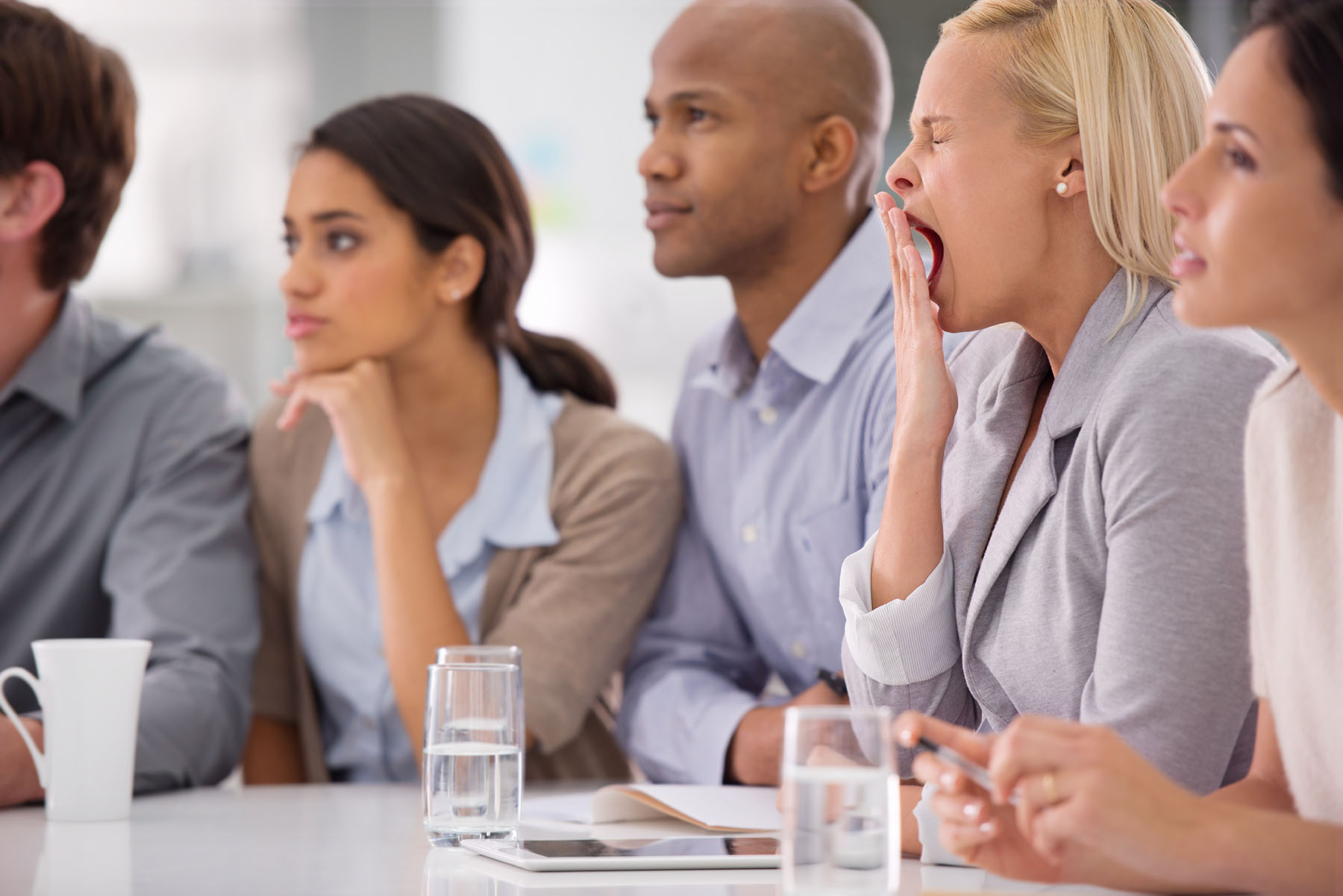 Woman yawns in work meeting