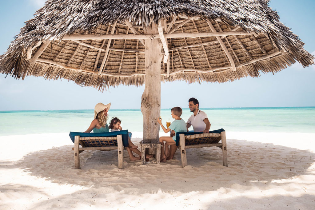 Family at beach under big shade canopy