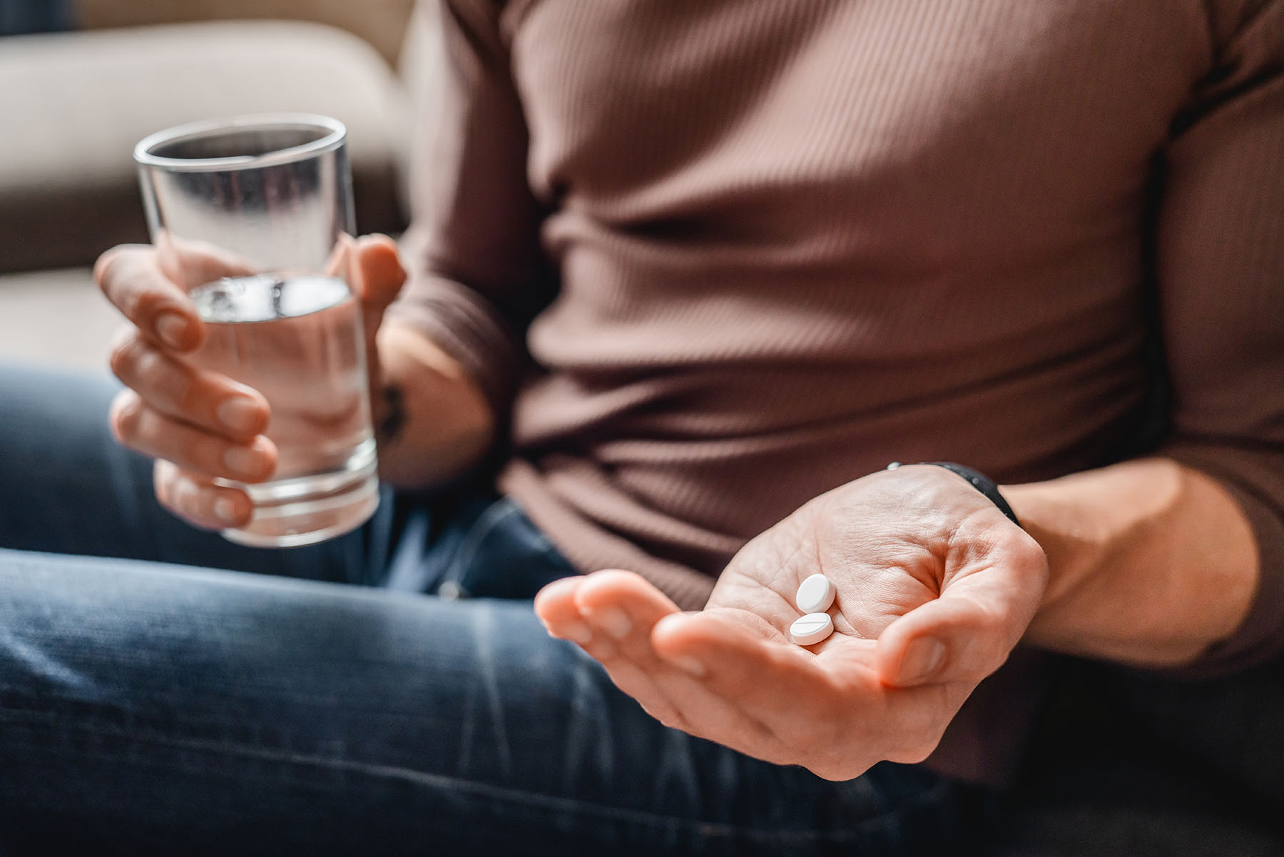 close up hands with aspirin and water