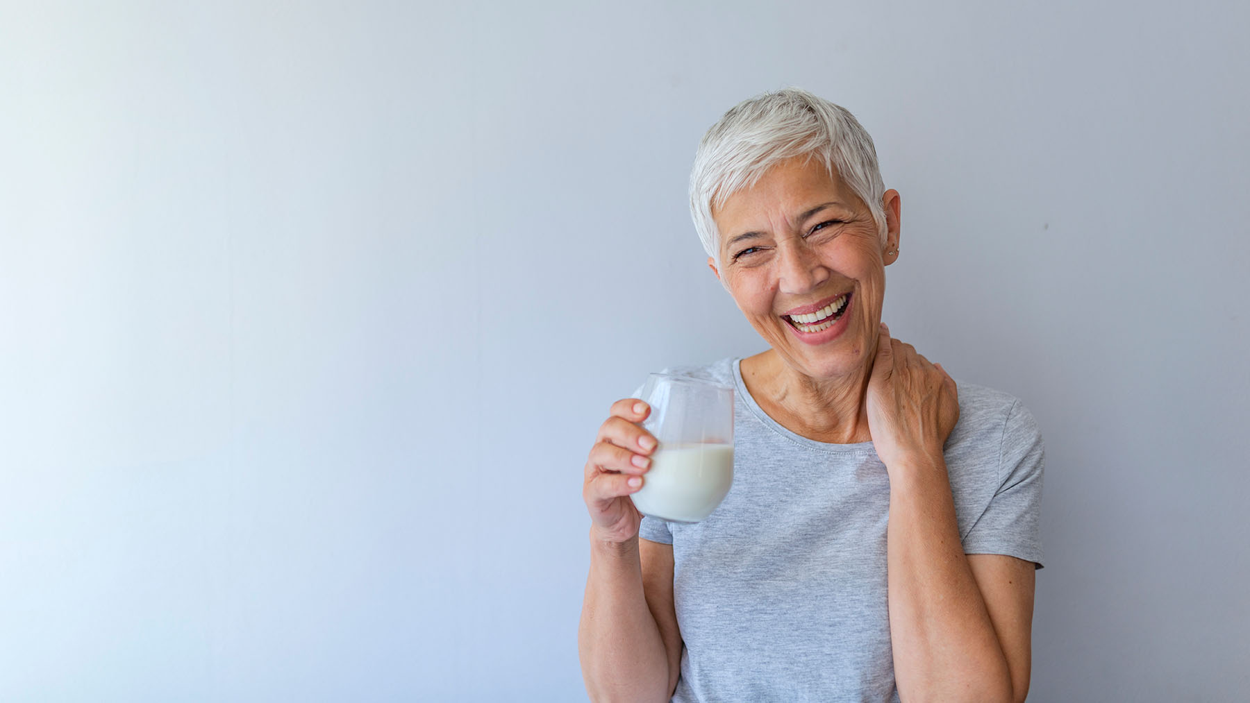 Happy older woman drinks milk