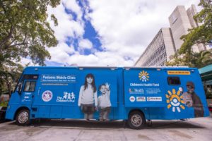 The blue UHealth Pediatric mobile clinic is featured