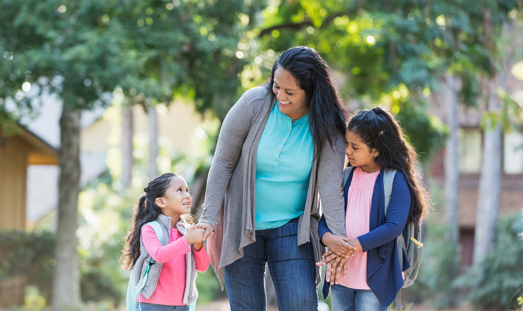 Hispanic mom walks daughters to school