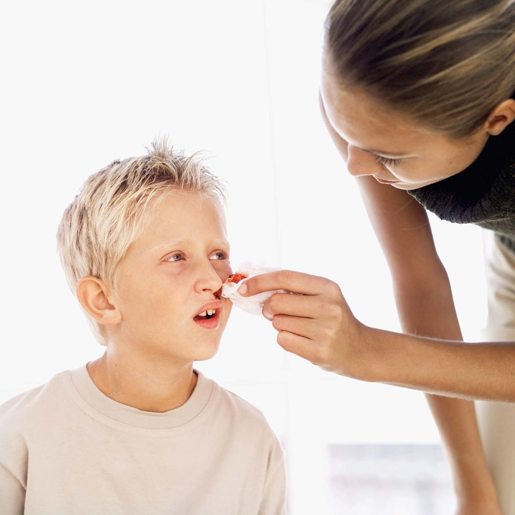 Mom tending to little boy with nosebleeds