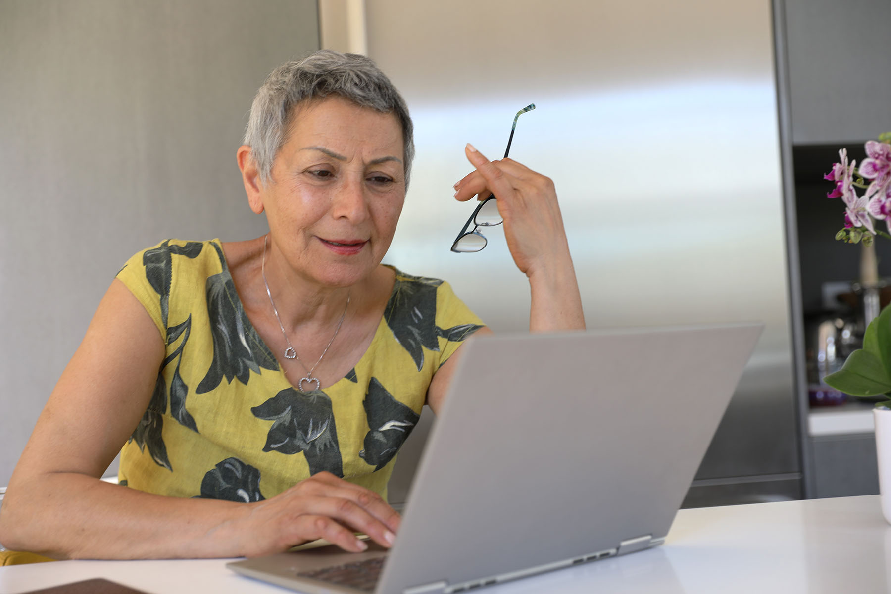 Hispanic woman with short hair looks distressed while researching cancer online