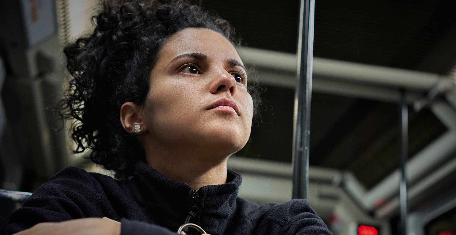 Young Hispanic woman looks anxious on metro rail car.