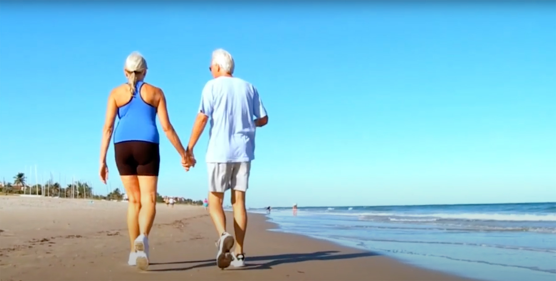 Older couple walking down beach
