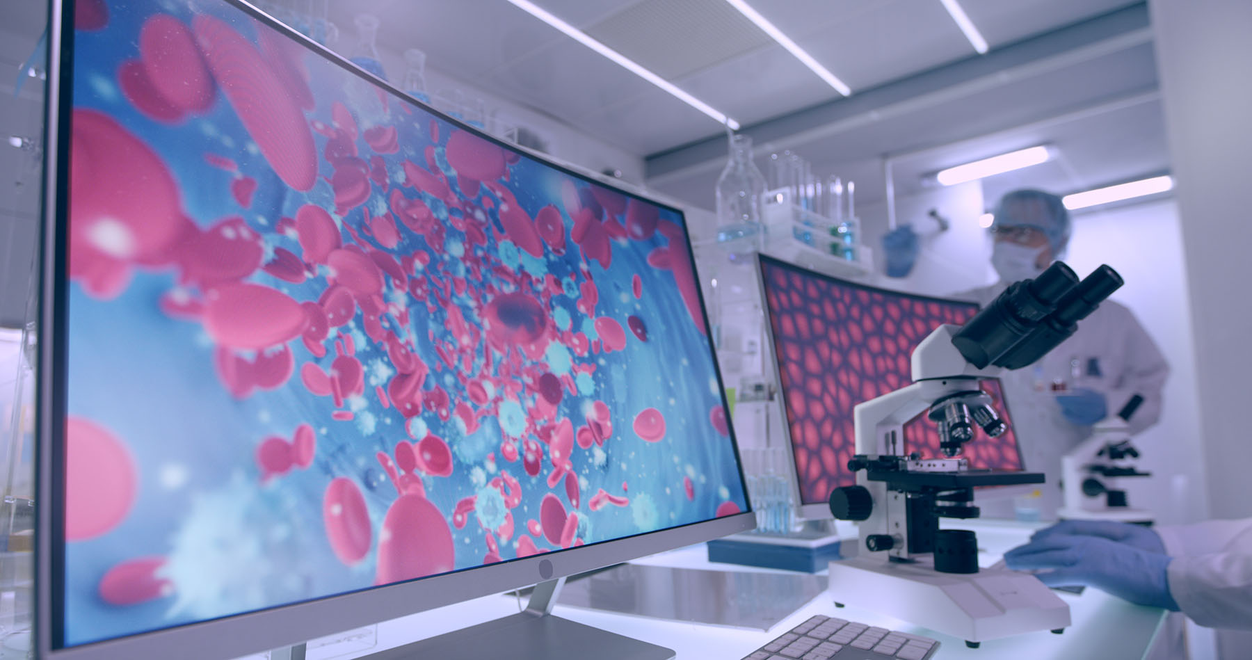 Futuristic shot of medical lab showing two screenings analyzing blood cells.