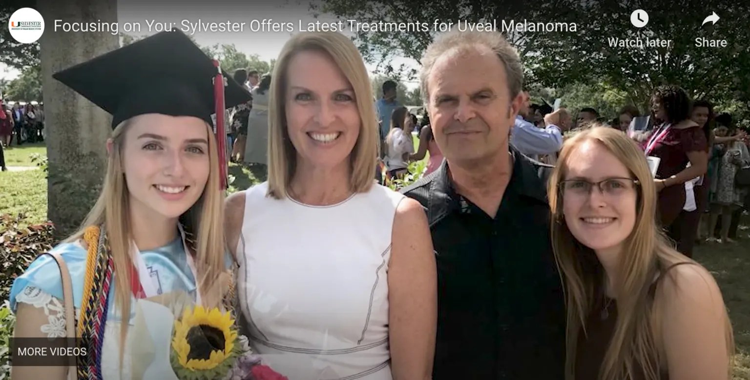 A happy graduate in cap and gown, holding a sunflower, smiles with her family at an outdoor celebration, accompanying content about Sylvester's treatments for uveal melanoma.