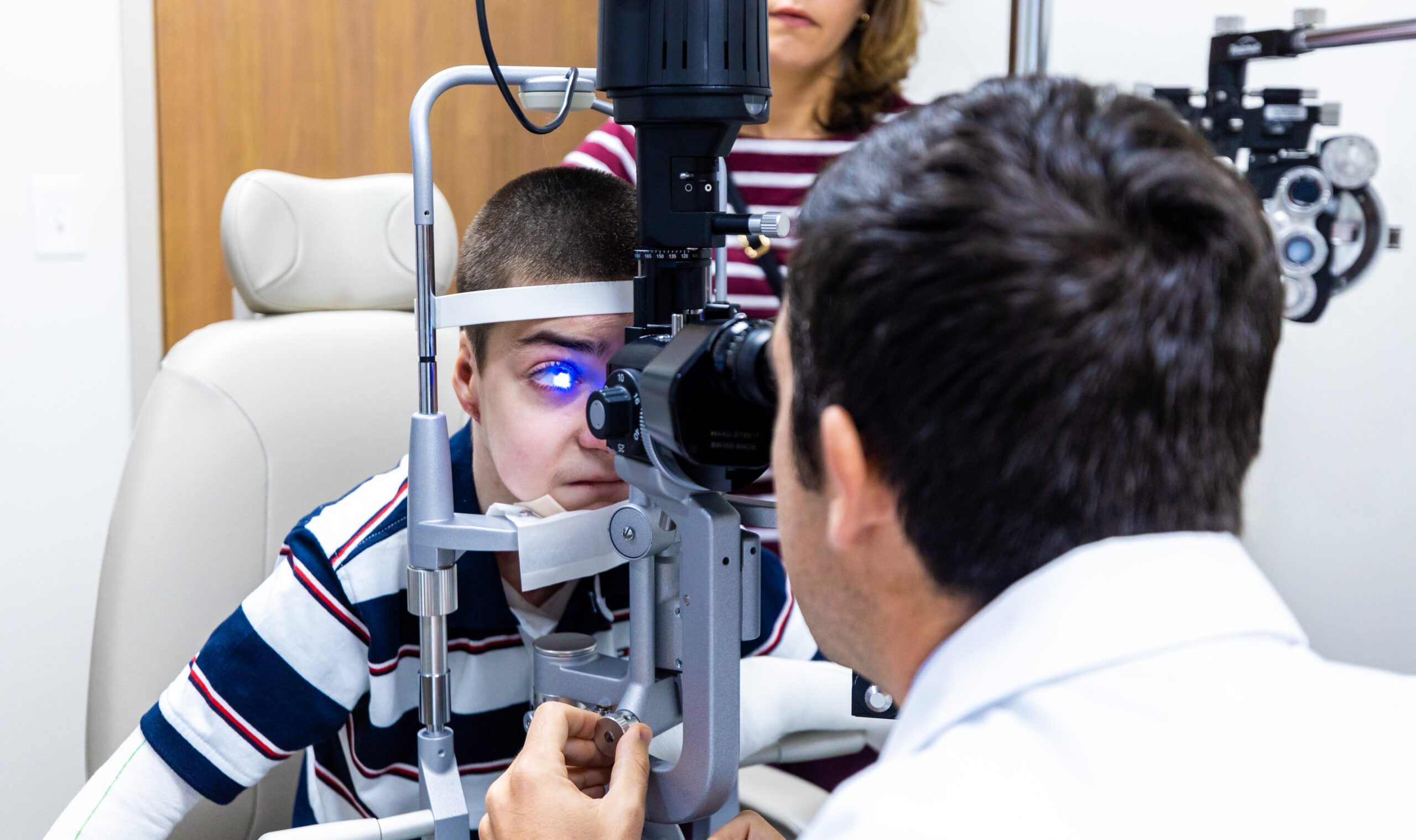 Dr. Sabater inspects Antonio's vision during an eye exam.