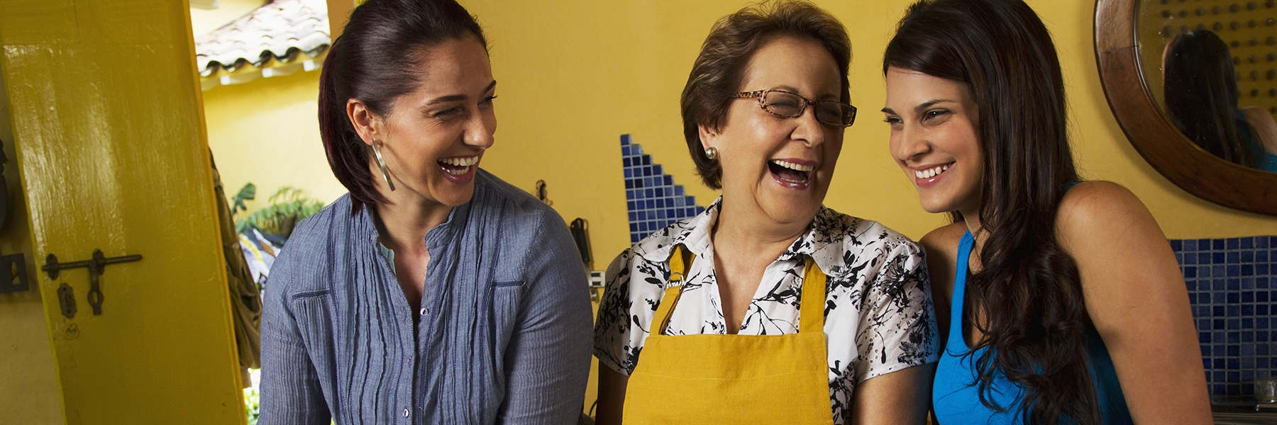 family of health Hispanic women cooking together and laughing