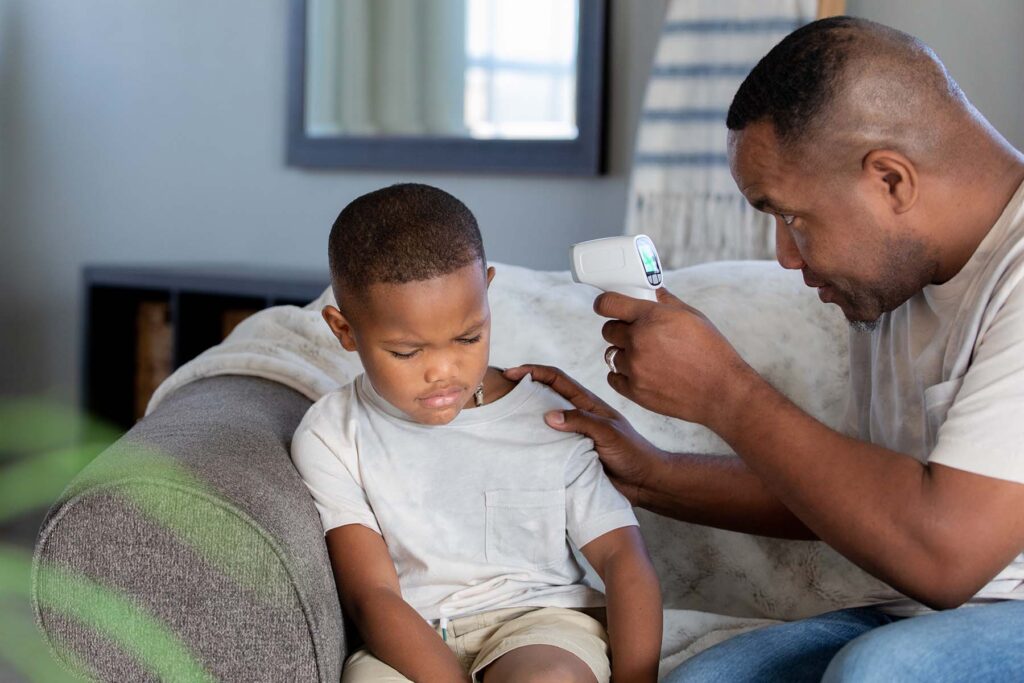 Concerned Dad takes son's temperature.