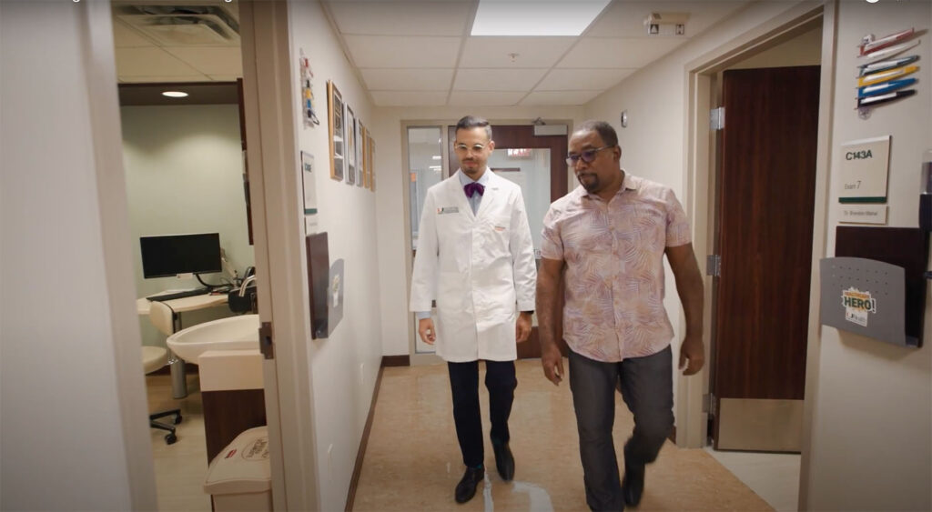 Dr. Mahal and prostate cancer patient walk the hallways of Sylvester Comprehensive Cancer Center.