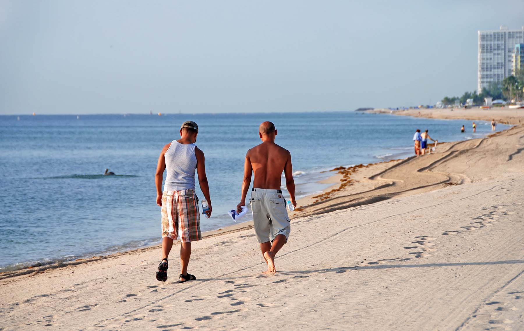 Two men walking down the beach in Miami.