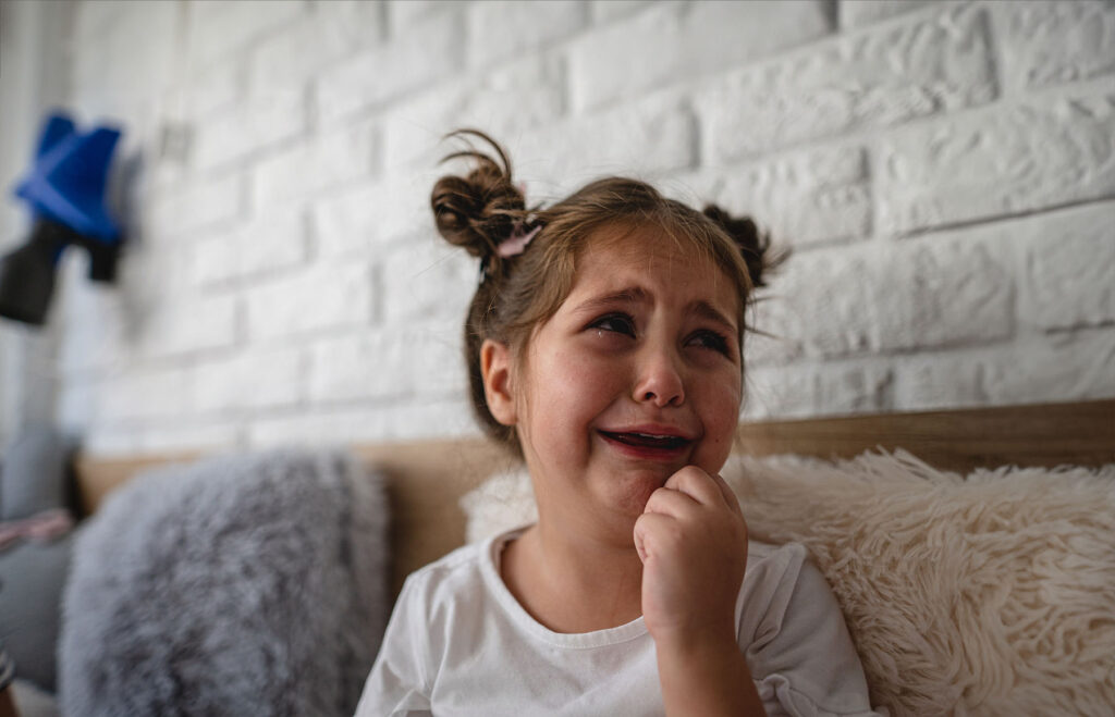 Beautiful little girl crying from growing pains.