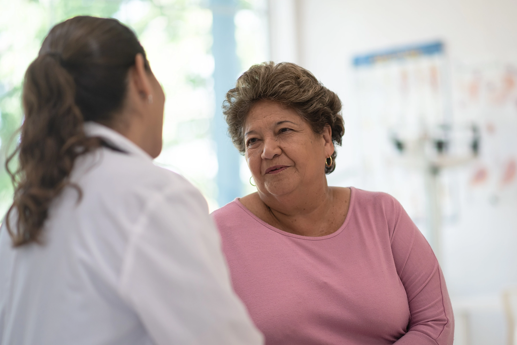 Heavyset Hispanic woman speaks with her doctor.