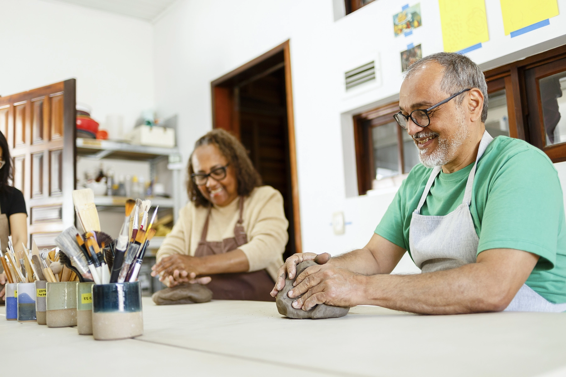 Senior Hispanic couple engages in a pottery class.