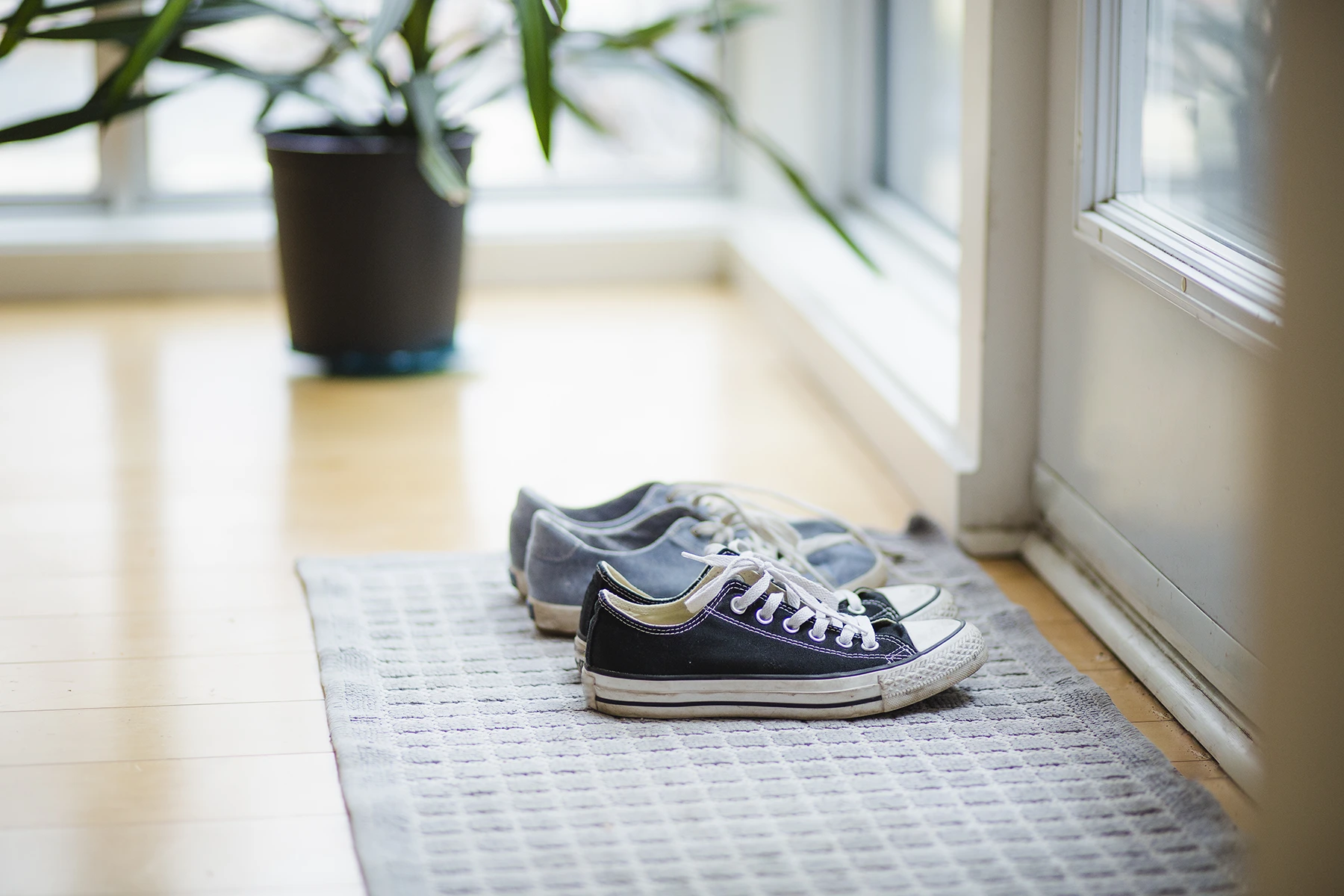 Kids left their canvas shoes by the front door to minimize the spread of germs.