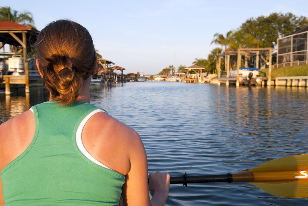 Woman with a sunburn kayaks in Florida.