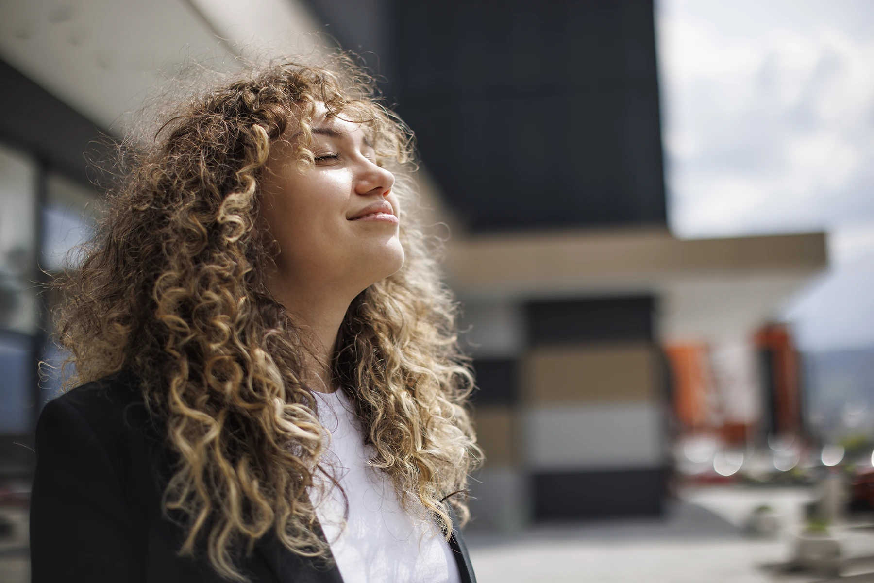 Young professional woman takes a moment outside to build her self confidence.