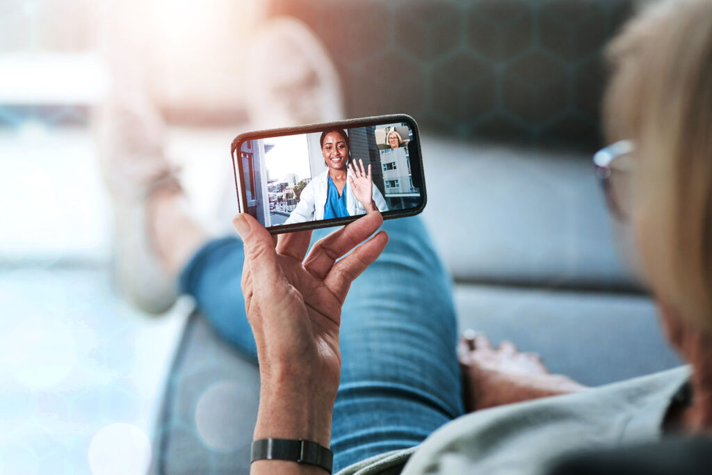 Woman speaking to a health care provider on a cell phone with video image