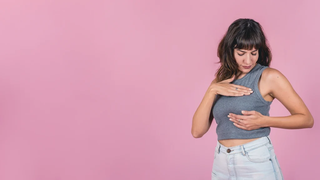 Woman performs self breast exam.