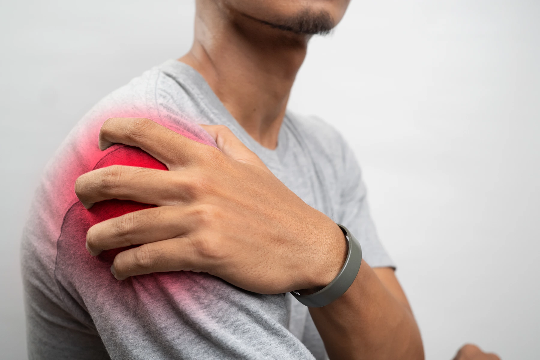 Close up photo of man holding his shoulder