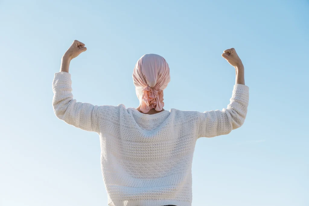 Empowerment photo of the back of a breast cancer survivor flexing her biceps in a show of strength