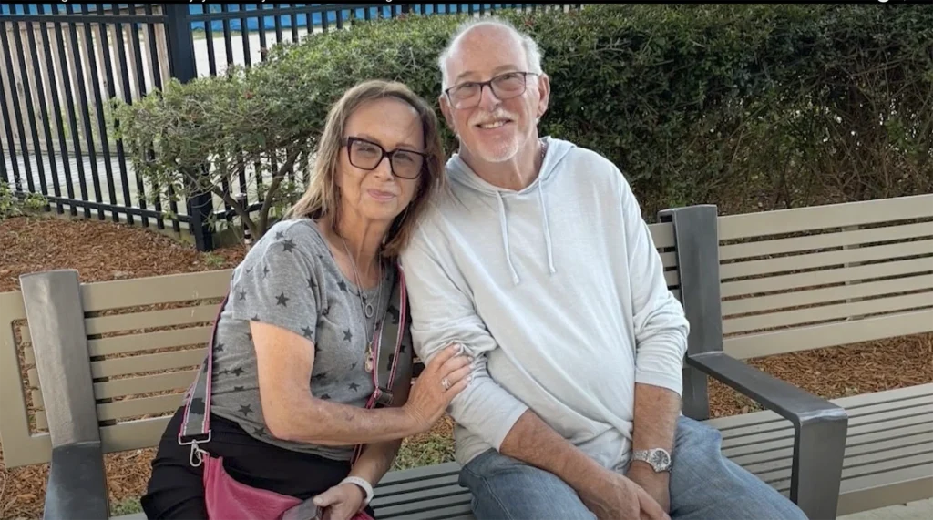 Endocrine cancer patient Lori Rothman sits with friend on a bench outside.