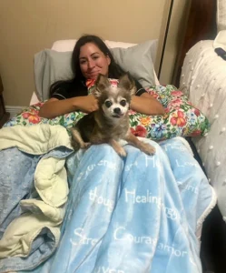 Brittany Malo relaxes with her dog on her lap.
