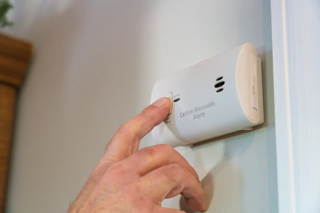 Photo of a hand testing the carbon monoxide detector.
