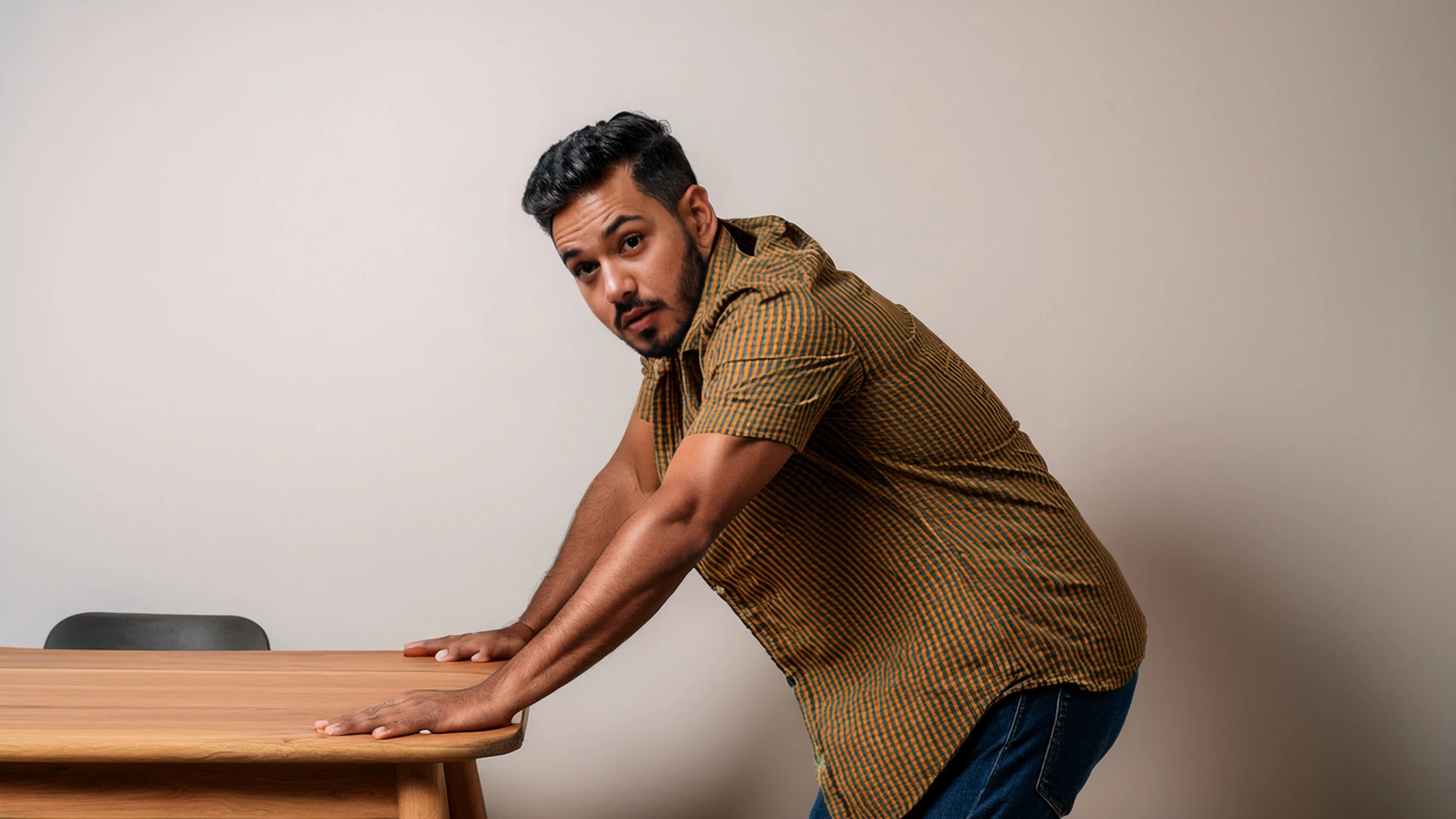 Hispanic man who just whacked his leg on table looks at camera, seeming to ask, why do I bruise so easily. Created with PhotoShop AI generation.