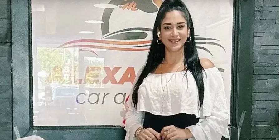 Paciente sonriente frente a un negocio automotriz, ejemplo del impacto positivo del páncreas artificial en su vida.